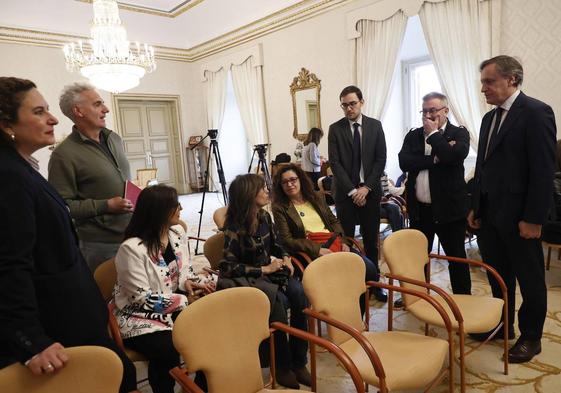 Ángel Fernández Silva, Miguel Ángel Benito y Carlos García Carbayo (de pie) charlan con representantes de escuelas de español de Salamanca, ayer en el Salón de Recepciones del Ayuntamiento.