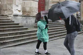 Viandantes enfrentándose al viento en la calle Compañía