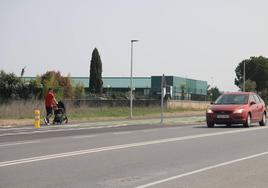 Un hombre pasea con un carrito de bebé por la zona peatonal del nuevo carril bici de Villamayor.