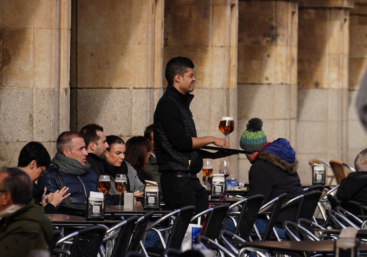 Un camarero sirviendo una caña en una terraza de la Plaza Mayor.