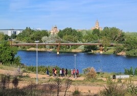 Un grupo de personas pasean por la margen izquierda del río Tormes en Salamanca.
