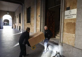Dos operarios trasladando documentos del Palacio de Justicia.