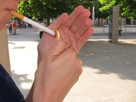 Persona encendiéndose un cigarro