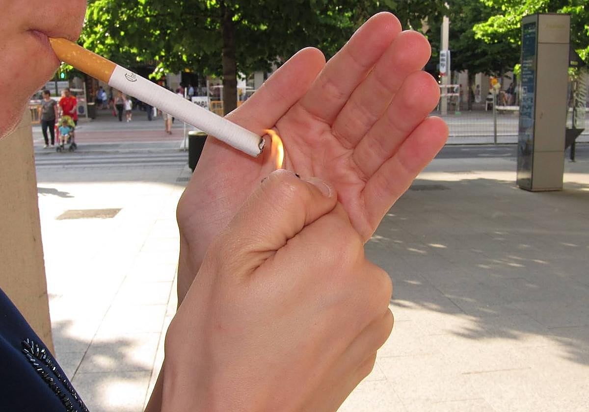 Persona encendiéndose un cigarro