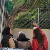 Tres vecinas de los edificios 9 y 11 de la calle Arco del Monte contemplando la parte del terraplén desprendida la semana pasada.