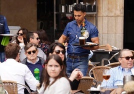 Un camarero atendiendo las mesas de una terraza de la Plaza Mayor.