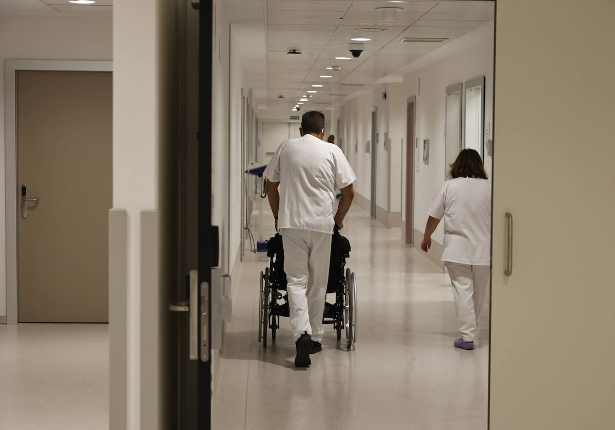 Personal sanitario del Hospital transportando a un paciente en silla de ruedas.