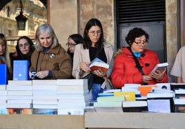 Tres mujeres muestran interés por los libros en la Plaza Mayor