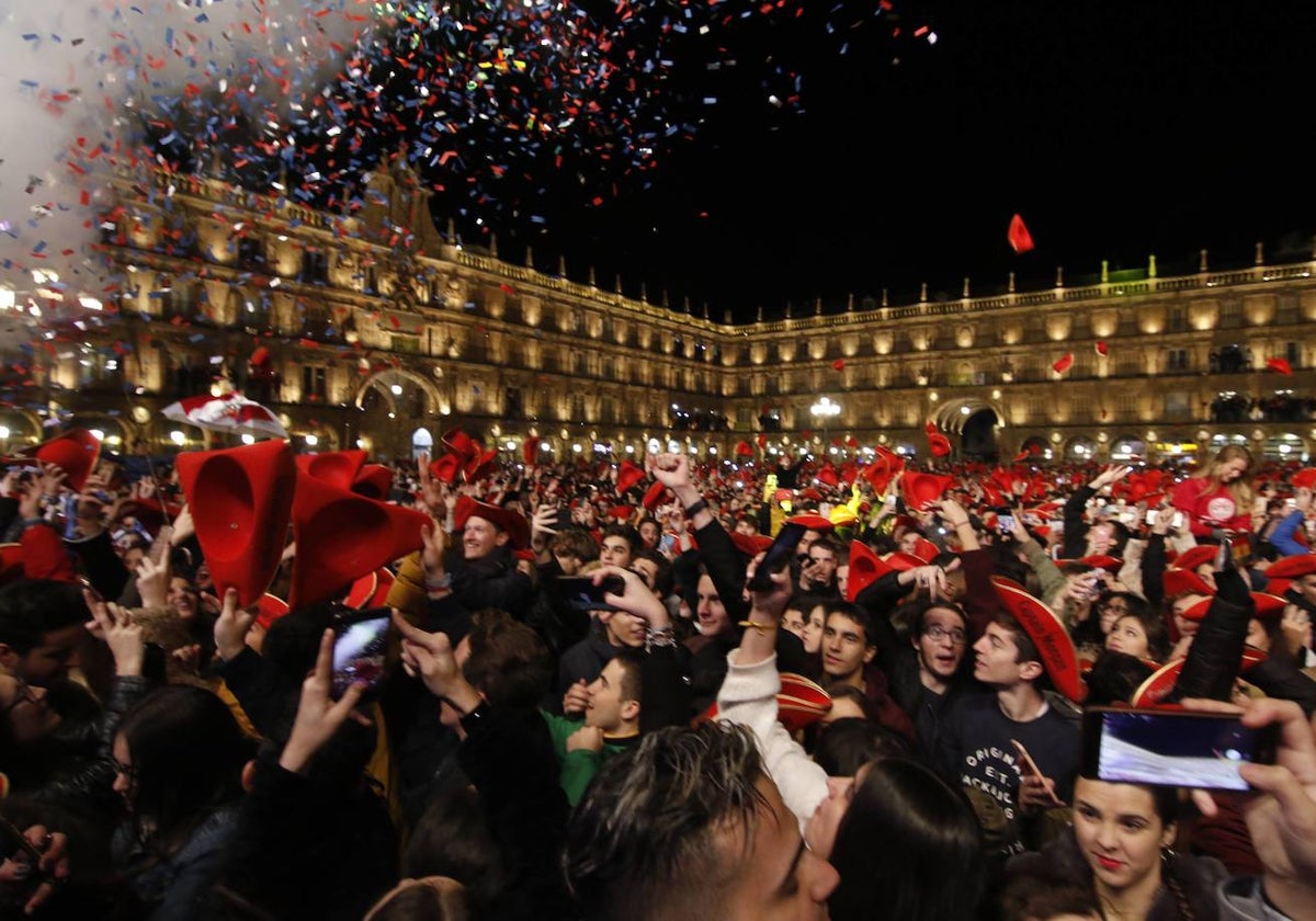 Jóvenes con móviles durante la Nochevieja Universitaria del año 2018 en la Plaza Mayor.