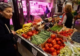 Una señora pregunta el precio de la judía verde en una frutería salmantina.