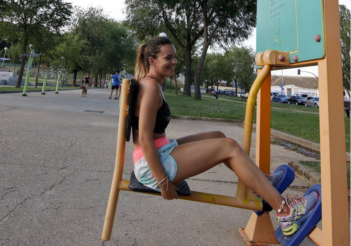 Una joven practica ejercicio físico en un parque de biosaludables de la icudad