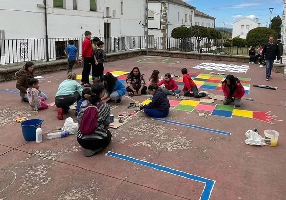 Los alumnos, manos a la obra pintando su espacio de juegos.