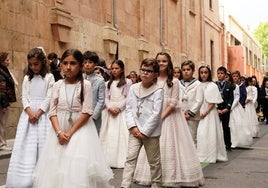 Un grupo de niños de comunión en una procesión.