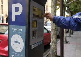 Un usuario deposita dinero en un parquímetro para obtener el tíquet.