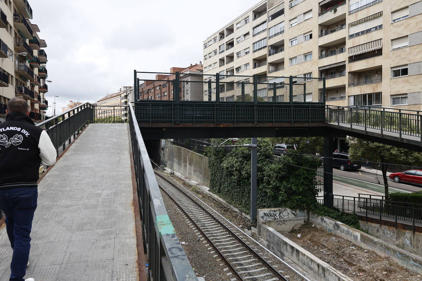 Un hombre sube por el paso elevado de la zona del apeadero de La Alamedilla.