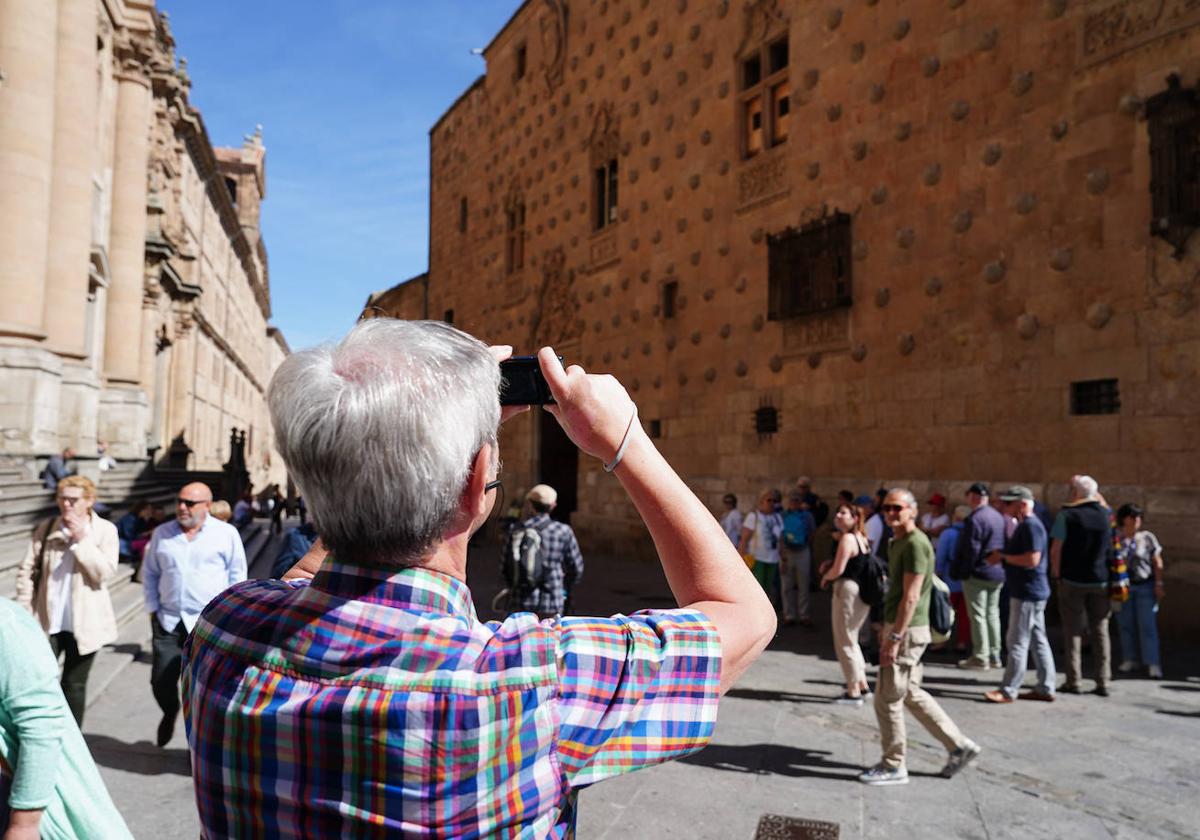 Turista le saca una foto a la Casa de las Conchas en un día soleado