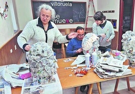 Voluntarios trabajan en la fabricación de los gigantes a base de pasta de papel de periódico.