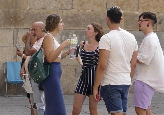 Algunas personas en el centro de Salamanca, combatiendo el calor con agua.