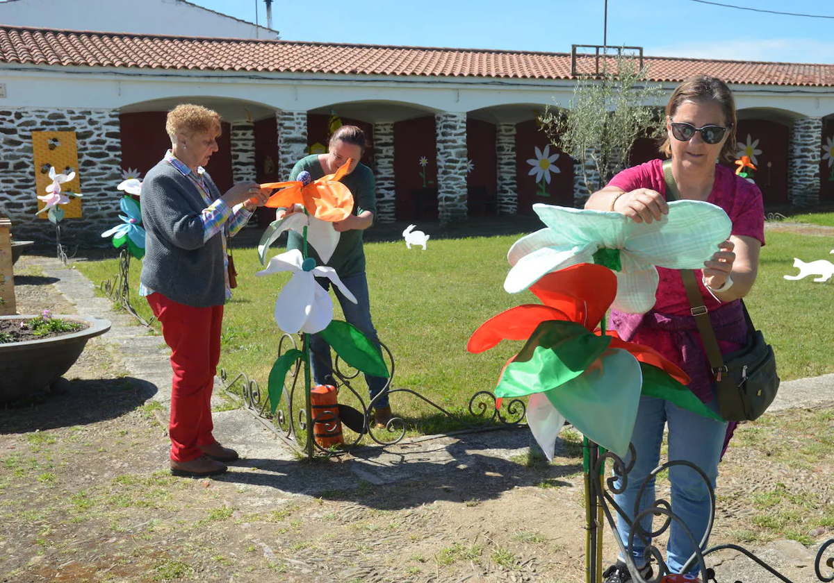 Las vecinas colocando los últimos detalles del jardín