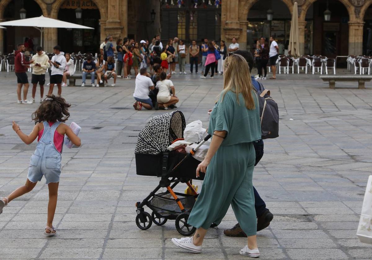 Una pareja de Salamanca pasea con un carrito de bebé.