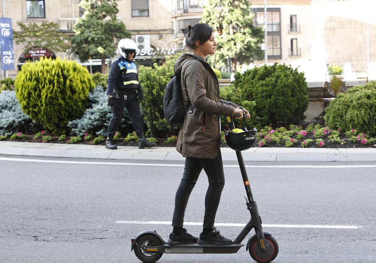 Una joven pasea con patinete eléctrico por Salamanca.