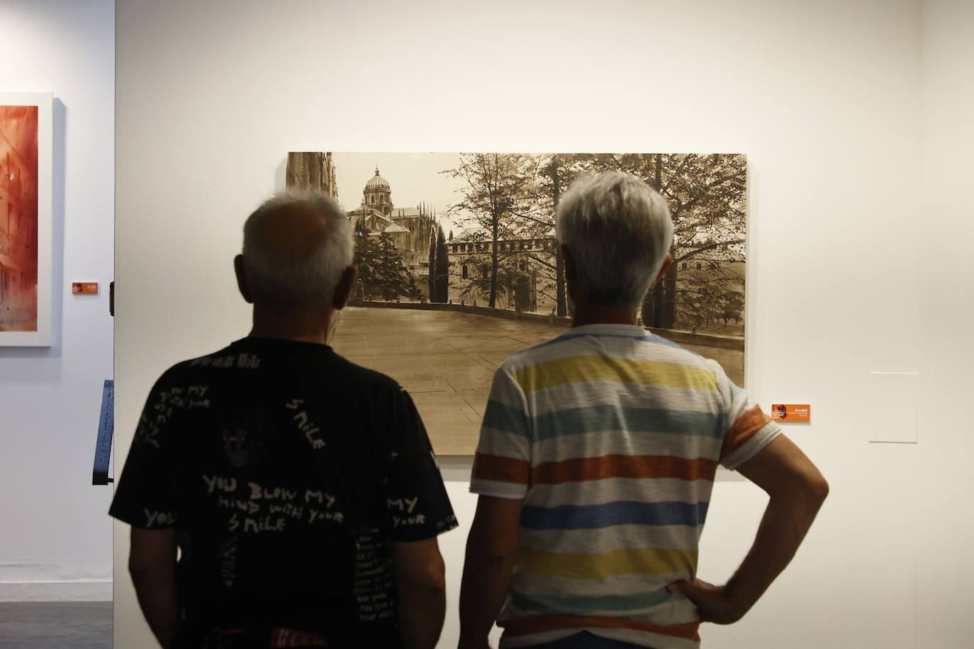 Dos personas observando una obra que refleja la Catedral.