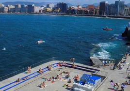 Bañistas toman el sol en Gijón.