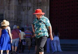 Una persona se cobija del calor con un sombrero en el centro de Salamanca.