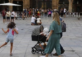 Familia con carricoche paseando por la Plaza Mayor.