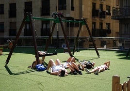 Imagen de unas jóvenes tomando el sol en un parque salmantino.