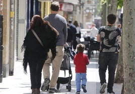 Un padre camina con un carrito de bebé por Salamaca.