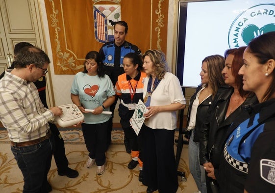 Un técnico muestra un desfibrilador semiautomático a la edil Vega Villar, a policías y representantes de asociaciones de afectados.