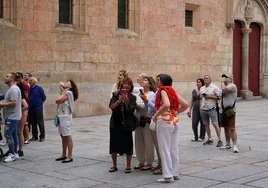 Un grupo de turistas contemplan la fachada histórica de la Universidad.