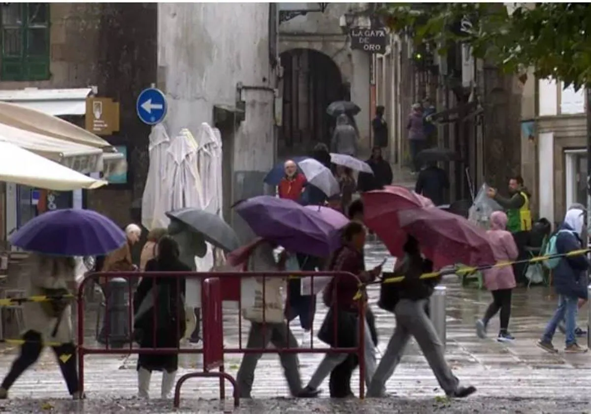 Ciudadanos se protegen con paraguas de la la lluvia.