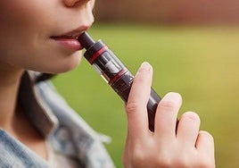 Una joven, con un vapeador.