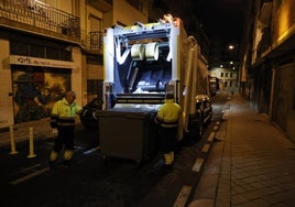 Operarios del servicio de recogida de basura con un camión.