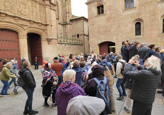 Decenas de turistas observan la fachada histórica de la Universidad.