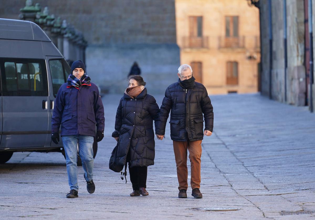 Tres salmantinos pasean por el centro de la ciudad en un día de frío.