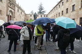 Turistas intentando taparse de la lluvia en Salamanca.