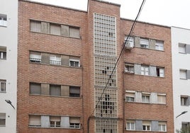 La fachada del edificio ocupado, con los cristales de la escalera rotos.