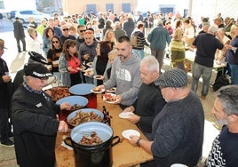 Reparto de la comida de matanza entre el público congregado