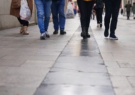 Varias personas, ajenas a esta información, caminan por las baldosas en cuestión en la calle Azafranal.