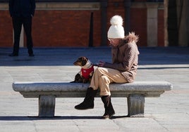 Una persona se cobija del frío con un gorro y un abrigo.