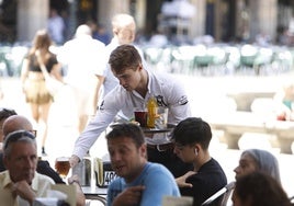 Un camarero atendiendo una terraza de la Plaza Mayor.