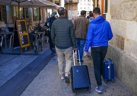 Un grupo de viajeros con maletas por la calle Zamora.