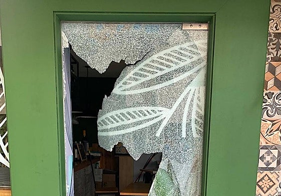El cristal de la puerta de uno de los locales, reventada.