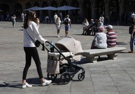 Una mujer empujando un carrito de bebé.