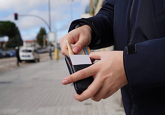Un salmantino introduce dinero en su cartera.