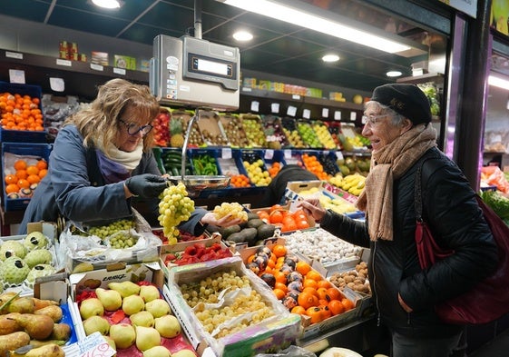 Nati Rodríguez sujeta dos racimos de uvas en su puesto.