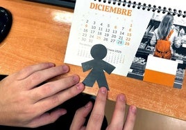 Un joven coge un calendario con el Día de los Santos Inocentes rodeado en azul.